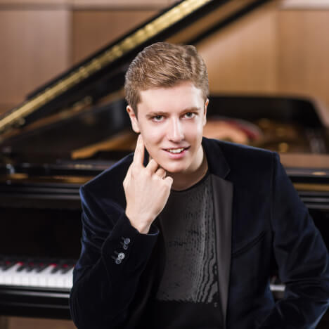 portrait of Vladislav Kern in front of a piano